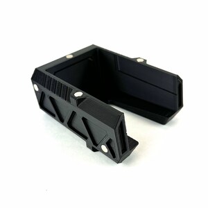 May include: Black plastic phone stand with a geometric design and magnetic closures.