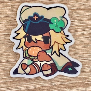 May include: A die-cut sticker featuring a cartoon character in a military-style hat and uniform, eating a hamburger. The character has blonde hair, brown skin, and is wearing a green and tan outfit. A four-leaf clover is on the hat.
