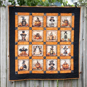 May include: A Halloween-themed quilt with a black border and orange squares. Each square features a different spooky character, including an owl, pumpkin, spider, and ghost. The quilt is hanging on a wooden fence.