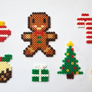 K&ouml;nnte beinhalten: Ein Set mit weihnachtlichen Perlen-Sprites, darunter ein Lebkuchenmann, ein Zuckerstange, ein Weihnachtsbaum, ein Weihnachtspudding, ein Weihnachtsbaumschmuck und zwei Geschenke.