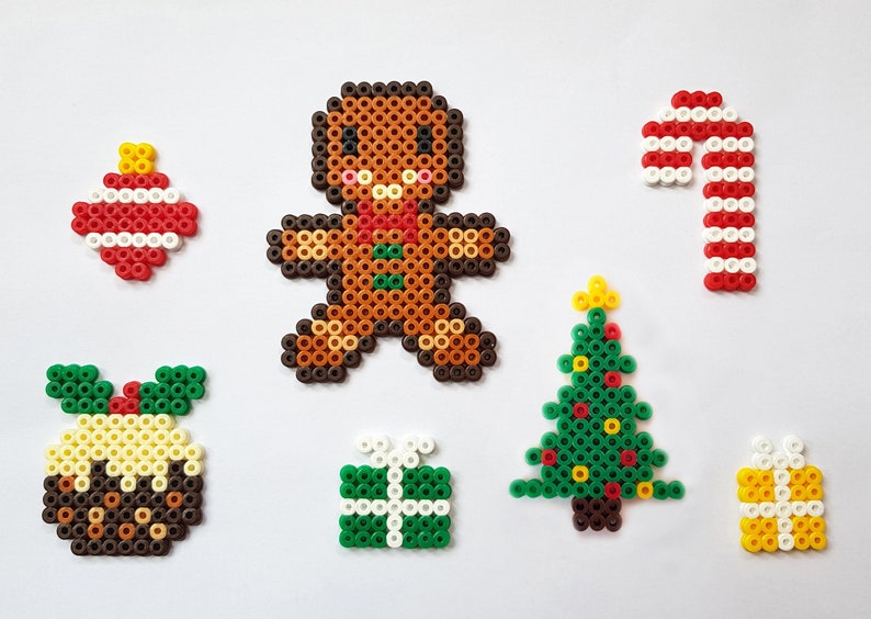 K&ouml;nnte beinhalten: Ein Set mit weihnachtlichen Perlen-Sprites, darunter ein Lebkuchenmann, ein Zuckerstange, ein Weihnachtsbaum, ein Weihnachtspudding, ein Weihnachtsbaumschmuck und zwei Geschenke.
