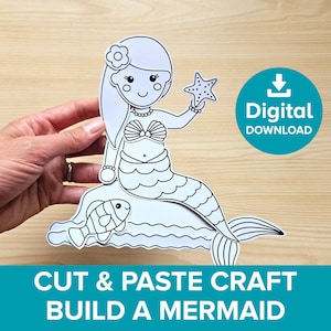 May include: A black and white mermaid cut-and-paste craft. The mermaid is holding a starfish and is sitting on a wave with a fish. The image also includes a digital download icon and the text "Cut & Paste Craft Build a Mermaid."