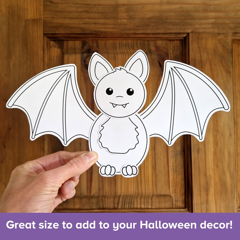 Op de afbeelding: Een zwart-witte printbare vleermuis uitsnede. De vleermuis heeft grote vleugels en een schattig gezicht met grote ogen en kleine tanden.  Ideale maat om toe te voegen aan je Halloween decoratie!