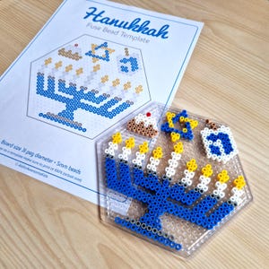 May include: A Hanukkah menorah fuse bead template with a blue base, white candles, and yellow flames. The template is surrounded by a blue and white Star of David, a dreidel, and a donut.