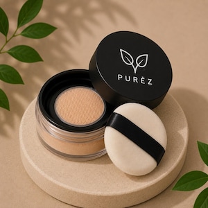 Op de afbeelding: Een doorzichtige pot losse gezichtspoeder met een beige tint, een zwart deksel met het woord "PUREZ" en een bladerontwerp, en een witte poederdons met een zwart lint. De pot staat op een beige cirkelvormig platform.