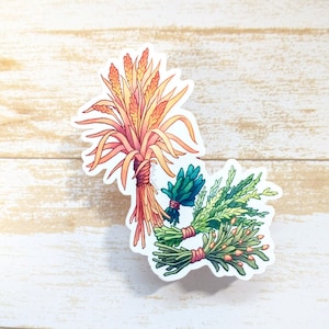May include: A sticker featuring a watercolor illustration of three bundles of dried herbs. The bundles are tied with twine and feature a variety of colors, including green, yellow, orange, and red. The bundles are arranged in a semi-circle shape.