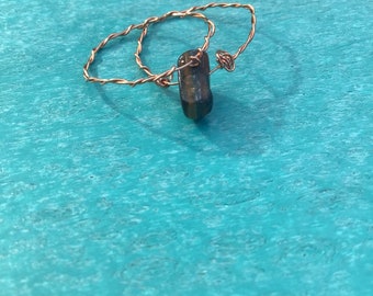 May include: Two copper wire rings with a brown and gold tiger's eye stone hanging from the bottom.