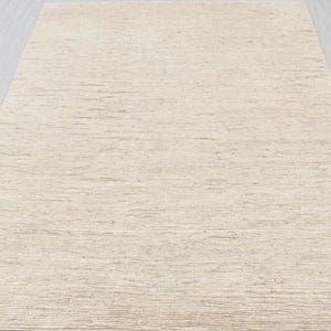 May include: A close-up of a beige textured wallpaper with a subtle horizontal striped pattern.