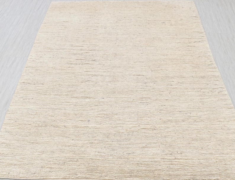 May include: A close-up of a beige textured wallpaper with a subtle horizontal striped pattern.