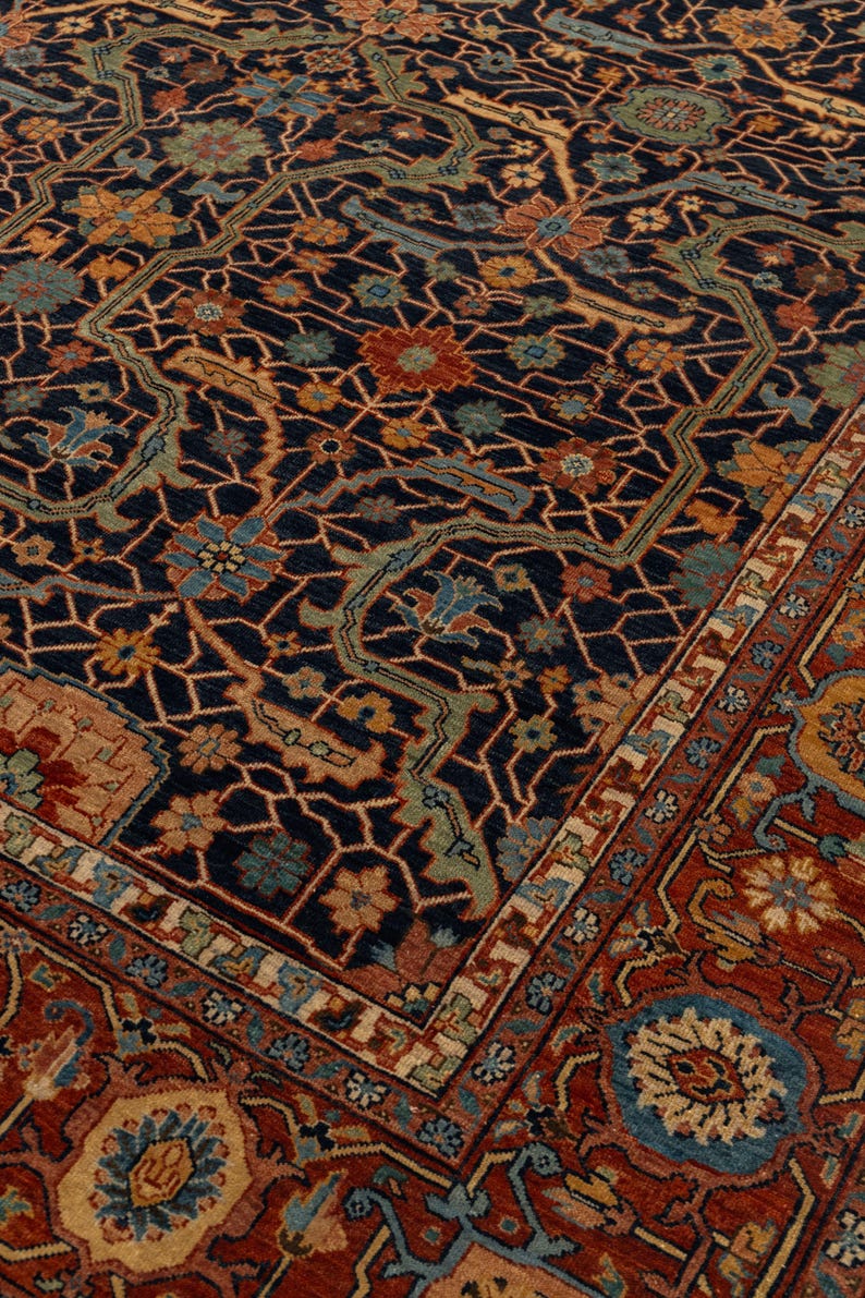 May include: An ornate, rectangular rug with a dark blue background and a complex floral pattern in shades of red, orange, and blue. The rug has a detailed border and intricate design.