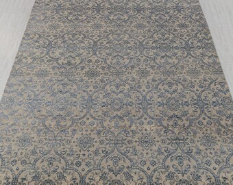 Puede incluir: Una alfombra beige y azul con un diseño tradicional. La alfombra tiene un brillo sutil y una textura suave.