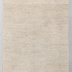 May include: A plain, off-white woven rug with a subtle texture. The rug is made of natural fibers and has a slightly rough surface.