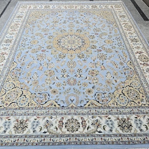 May include: A large, rectangular area rug with an intricate floral pattern. The rug features a light blue background with cream, beige, and burgundy accents. The design includes a central medallion and detailed borders.