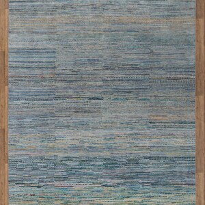 May include: A rectangular rug with a woven texture, featuring a blend of blue, teal, and beige hues. The rug has a fringed edge and measures 8 x 10 ft. The item code is 4648.