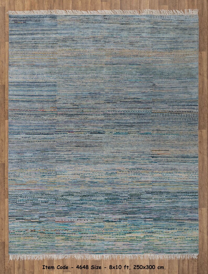 May include: A rectangular rug with a woven texture, featuring a blend of blue, teal, and beige hues. The rug has a fringed edge and measures 8 x 10 ft. The item code is 4648.