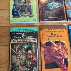 May include: A collection of vintage fantasy adventure books, including titles like "Return to Brookmere" and "The Dragon's Ransom." The books feature colorful covers with illustrations of dragons, warriors, and other fantasy elements. The books are from the "Dungeons & Dragons" and "Endless Quest" series.