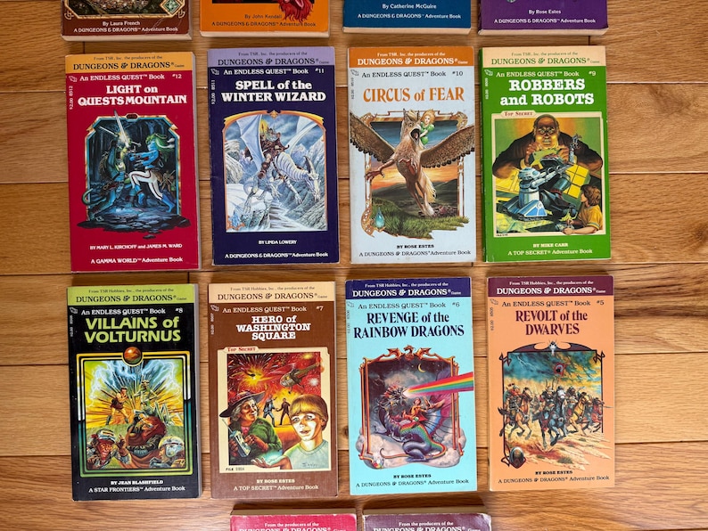 May include: A collection of vintage "Dungeons & Dragons" adventure books. The books feature colorful covers with fantasy illustrations, including dragons, wizards, and other mythical creatures. Titles include "Light on Quests Mountain" and "Revolt of the Dwarves."