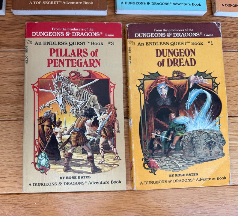 May include: Two vintage "Dungeons & Dragons" adventure books. One is titled "Pillars of Pentegarn" and the other "Dungeon of Dread." Both books feature colorful illustrations of fantasy scenes with characters and monsters. The books are in good condition.