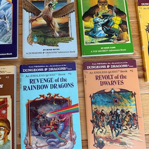 May include: A collection of vintage "Dungeons & Dragons" adventure books. Titles include "Circus of Fear", "Robbers and Robots", "Revenge of the Rainbow Dragons", and "Revolt of the Dwarves". The books feature colorful illustrations and text on the covers.