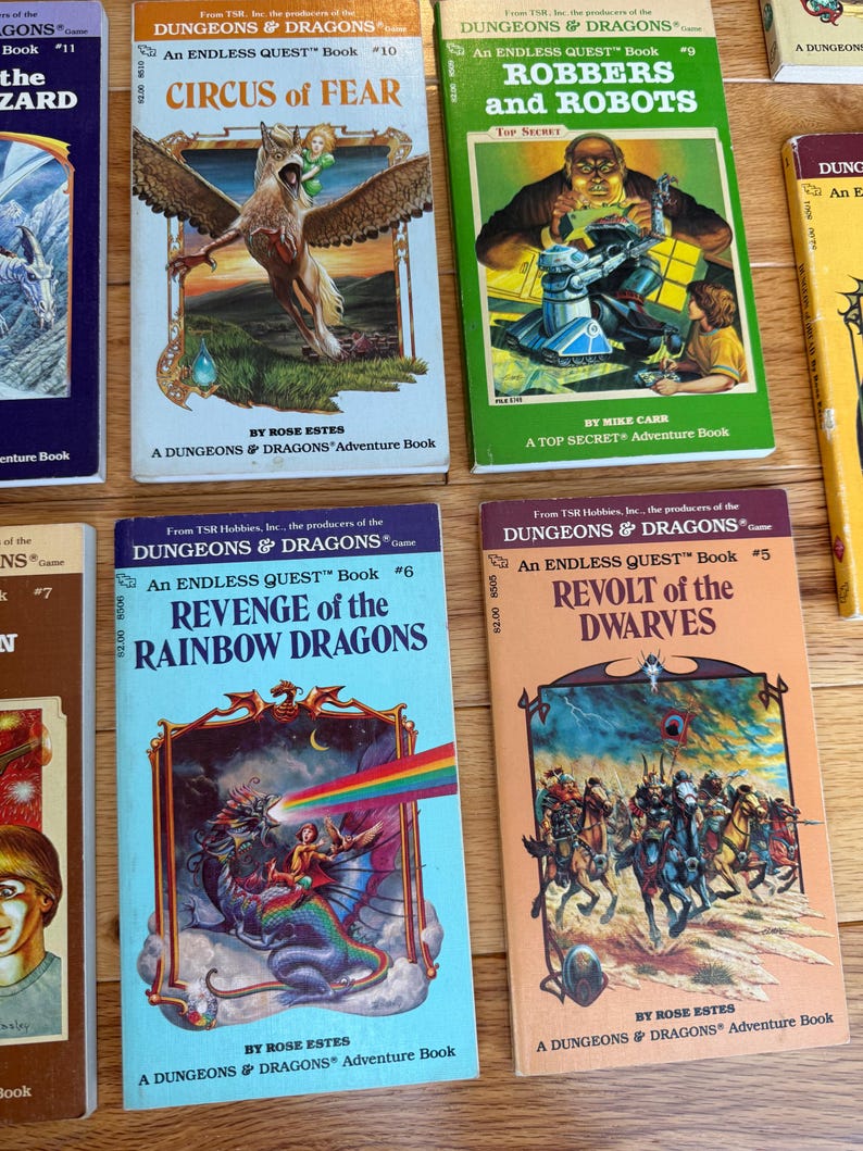 May include: A collection of vintage "Dungeons & Dragons" adventure books. Titles include "Circus of Fear", "Robbers and Robots", "Revenge of the Rainbow Dragons", and "Revolt of the Dwarves". The books feature colorful illustrations and text on the covers.