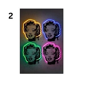 May include: Four black and white images of Marilyn Monroe with neon outlines in yellow, blue, green, and pink.