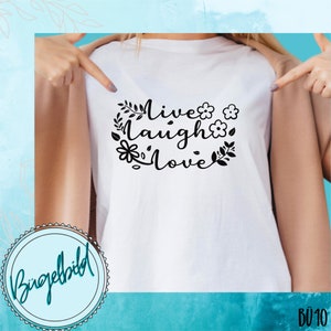 May include: White t-shirt with black text that reads "Live Laugh Love" surrounded by floral designs.