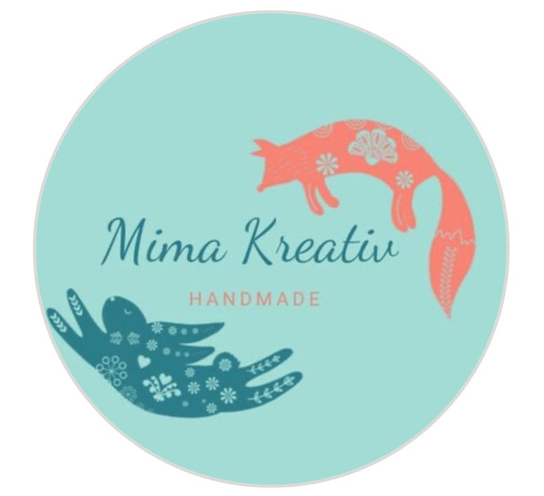 Op de afbeelding: Een turquoise cirkel met een roze vos en een blauwe konijn met bloemenpatronen. De tekst "Mima Kreativ Handmade" staat in het midden.