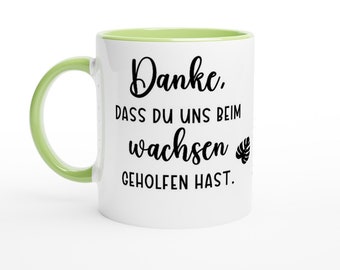 以下が含まれることがあります： 白のセラミックマグ。明るい緑色のハンドルと内側。マグには「Danke, DASS DU UNS BEIM wachsen GEHOLFEN HAST.」と書かれた黒い文字が書かれています。