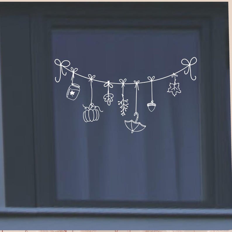 Op de afbeelding: Witte silhouet van een guirlande met herfstdecoraties die eraan hangen. De decoraties omvatten een pompoen, een pot met een blad, een tak met bessen, een bos bladeren, een eikel en een paraplu.