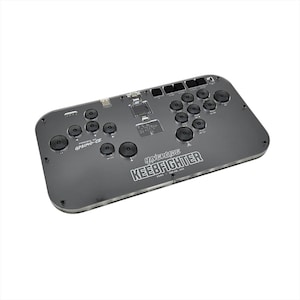 May include: A gray arcade controller with black buttons and a joystick. The controller has the text "Hypertype KEEBFIGHTER" and "GP2040-CE" printed on it. The controller is rectangular with rounded corners.