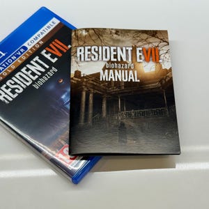 May include: A blue PlayStation 4 game case and a manual for Resident Evil VII: Biohazard. The game case has the game title in white and red text. The manual has the game title and the word "manual" in white text.