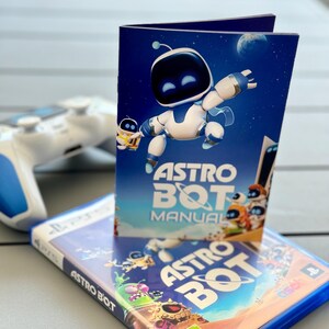 May include: A blue and white video game box with the title "ASTRO BOT" and a blue and white instruction manual with the title "ASTRO BOT MANUAL". The manual features a cartoon robot with blue eyes and a white body.