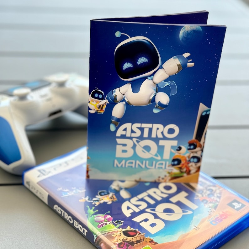 May include: A blue and white video game box with the title "ASTRO BOT" and a blue and white instruction manual with the title "ASTRO BOT MANUAL". The manual features a cartoon robot with blue eyes and a white body.