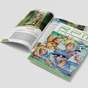 以下が含まれることがあります： 「Ratchet, Sly and Jak」と「RPM The Unofficial Retro Playstation Magazine」の文字が書かれたカラフルな表紙の雑誌。ビデオゲームのキャラクターのイラストが掲載されています。別のページには「PAXTER」のレビューが掲載されています。