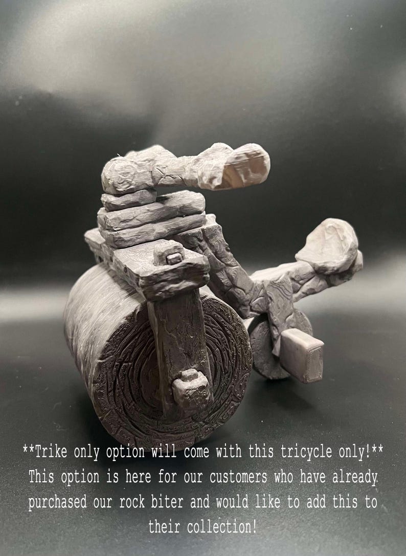 May include: A grey stone tricycle with a large front wheel and two smaller back wheels. The tricycle is made to look like a rock and has a stone seat and handlebars.