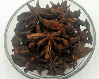 May include: A bowl filled with dried star anise, a popular spice used in Asian cuisine. The star anise is brown and has a slightly shiny appearance.