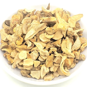 May include: A bowl of dried, light brown, irregularly shaped pieces of ginger root.