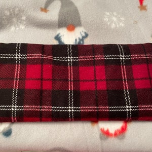 Könnte beinhalten: Roter und schwarzer karierter Stoff mit weißen Akzenten. Der Stoff ist weich und plüschig, perfekt für eine kuschelige Decke oder ein Kissen.