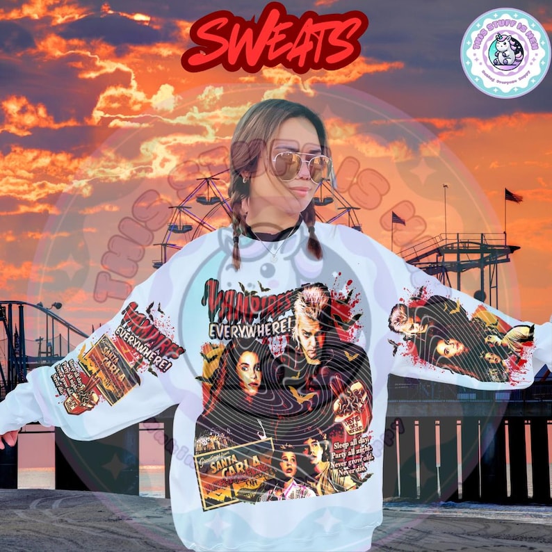 Pu&ograve; includere: Felpa bianca con grafica del film "The Lost Boys". Il design presenta il titolo del film, i personaggi e le parole "Santa Carla" e "Everywhere!". La parola "Sweats" &egrave; scritta in rosso in alto.