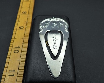 May include: Silver bookmark with a decorative design and the word "CLOVER" engraved on it. The bookmark is in a black velvet box.