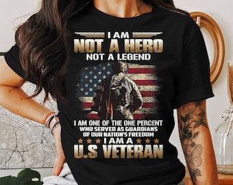May include: Black t-shirt with a graphic featuring a soldier in front of an American flag. Text reads "I AM NOT A HERO NOT A LEGEND" and "I AM A U.S. VETERAN."