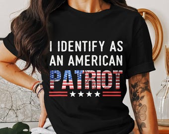 Peut inclure: T-shirt noir avec l'inscription "I IDENTIFY AS AN AMERICAN PATRIOT". Le mot "PATRIOT" est conçu avec un motif de drapeau américain rouge, blanc et bleu, avec trois étoiles blanches en dessous.