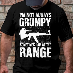 May include: Black t-shirt with white text that reads "I'm not always grumpy, sometimes I am at the range". A white silhouette of a person holding a rifle is above the text.