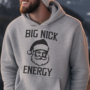 May include: A gray hooded sweatshirt with the text "BIG NICK ENERGY" and a black and white illustration of Santa Claus.