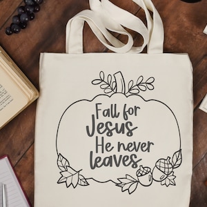 Könnte beinhalten: Eine weiße Einkaufstasche mit einer schwarz-weißen Grafik eines Kürbisses mit dem Text "Fall for Jesus He never leaves".
