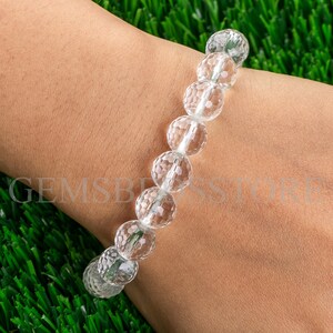 May include: A clear crystal bracelet with faceted beads. The bracelet is made of natural crystal and is designed to be worn on the wrist.