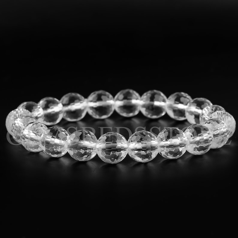 May include: A clear crystal bracelet with faceted beads. The bracelet is made of natural quartz crystals and is designed to be worn on the wrist.
