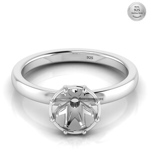 Può includere: Un anello d'argento con una fascia rotonda e un'incastonatura a forma di stella. L'anello è timbrato con "925" e ha un sigillo "Real 925 Sterling Silver Guarantee". L'anello è progettato per contenere una pietra preziosa.