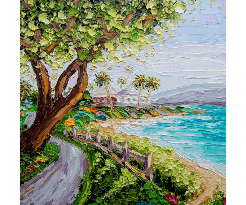 K&ouml;nnte beinhalten: Ein Gem&auml;lde, das eine Strandszene mit einem gro&szlig;en Baum im Vordergrund, einem wei&szlig;en Zaun und einem Weg zum Strand zeigt. Der Strand ist sandig mit blauem Wasser und Palmen im Hintergrund.