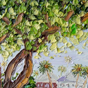 K&ouml;nnte beinhalten: Eine Nahaufnahme eines Gem&auml;ldes, das einen gro&szlig;en Baum mit braunen &Auml;sten und gr&uuml;nen Bl&auml;ttern zeigt. Der Baum befindet sich im Vordergrund des Gem&auml;ldes, und der Hintergrund ist ein hellblauer Himmel mit wei&szlig;en Wolken. Im Hintergrund befinden sich auch einige Palmen.